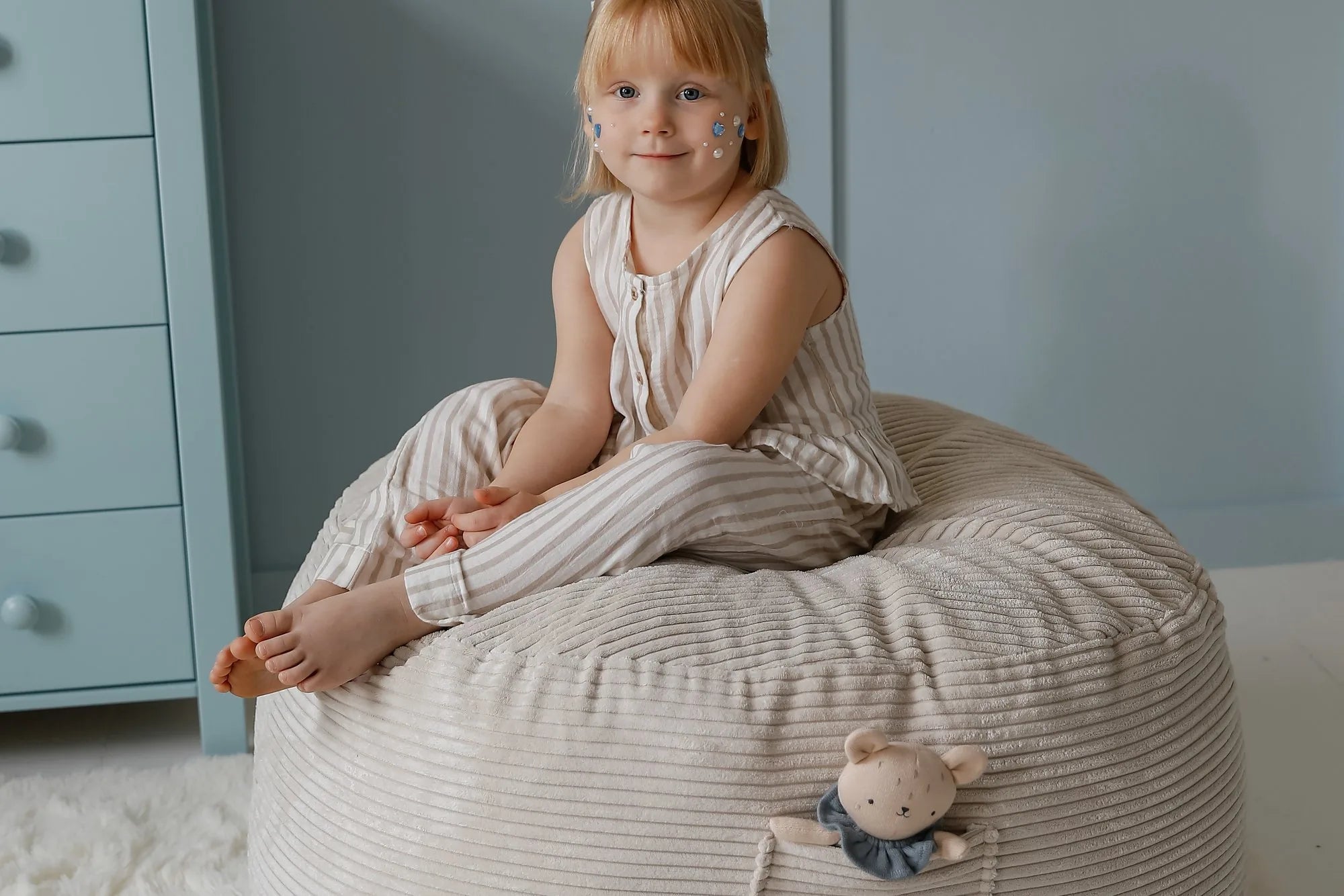 Dziewczynka siedzi w pufie Futon Bean Bag w kolorze Vanilla