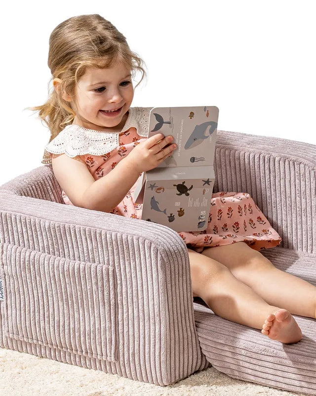Dziecko bawi się na foteliku Lumi Chair Corduroy