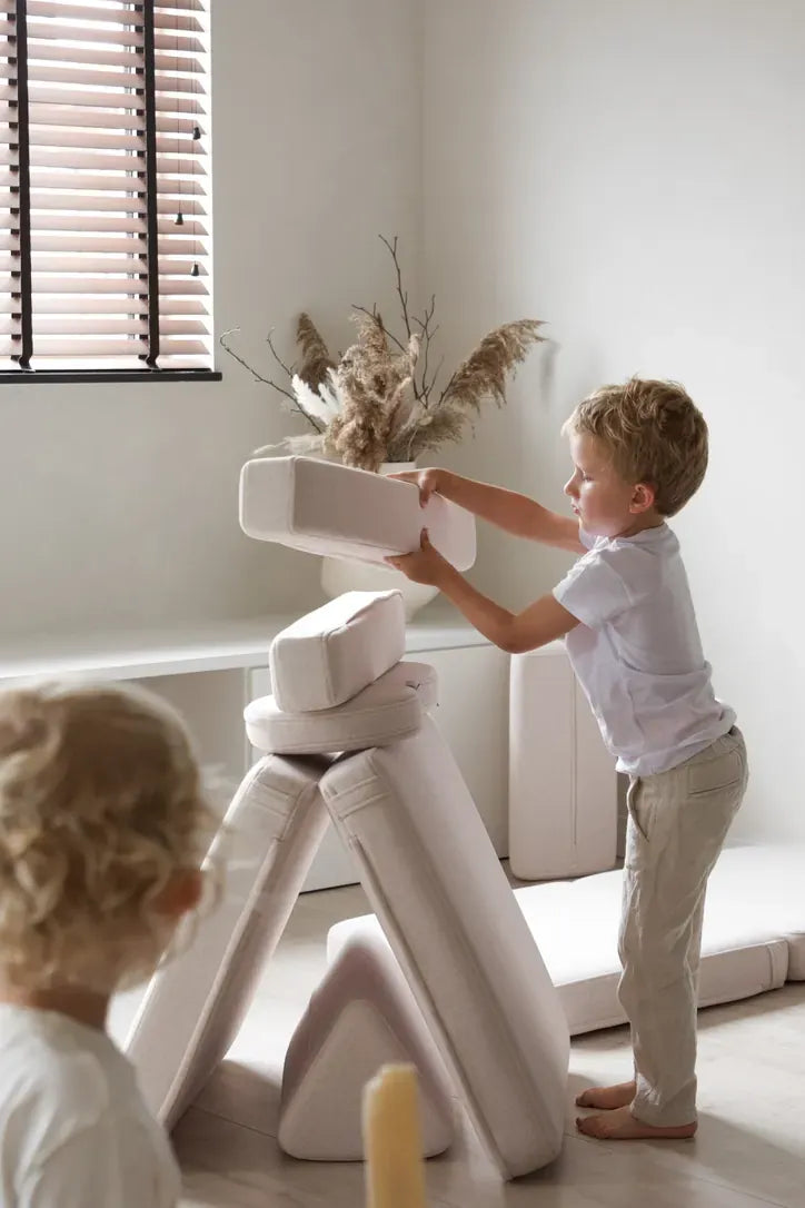 Dziecko układa elementy Play Sofa Original Mini w wieżę