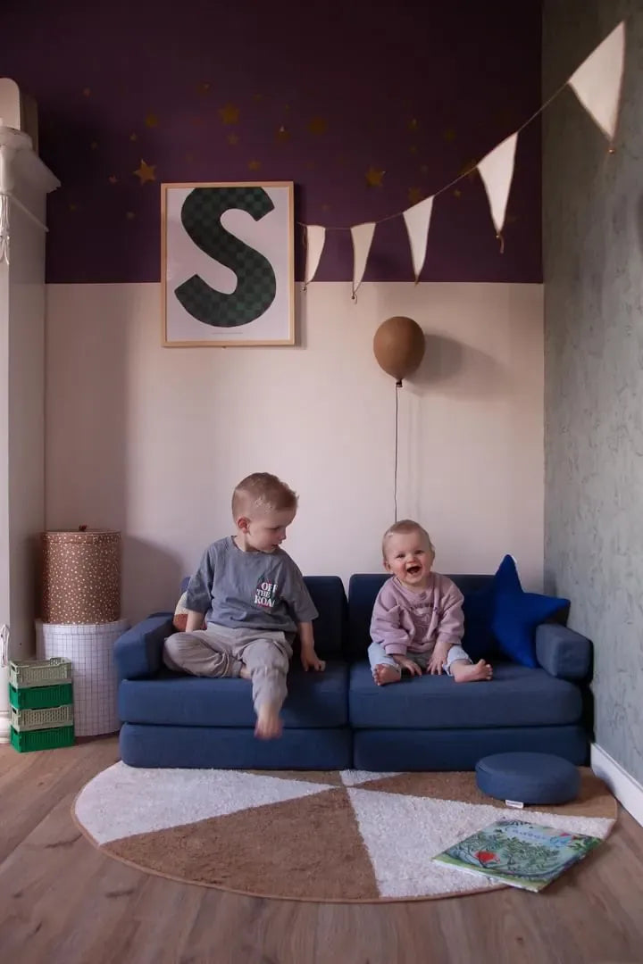 Dwoje maluchów siedzi na Play Sofa Original Mini w kolorze Navy Blue