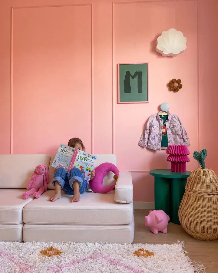 Dziecko czyta na Play Sofa Original w kolorze Soft Pink