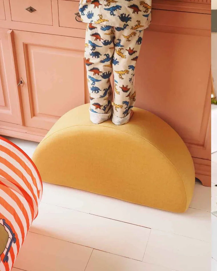 Dziecko stoi na Rockerze Ultra Plush w kolorze Mustard