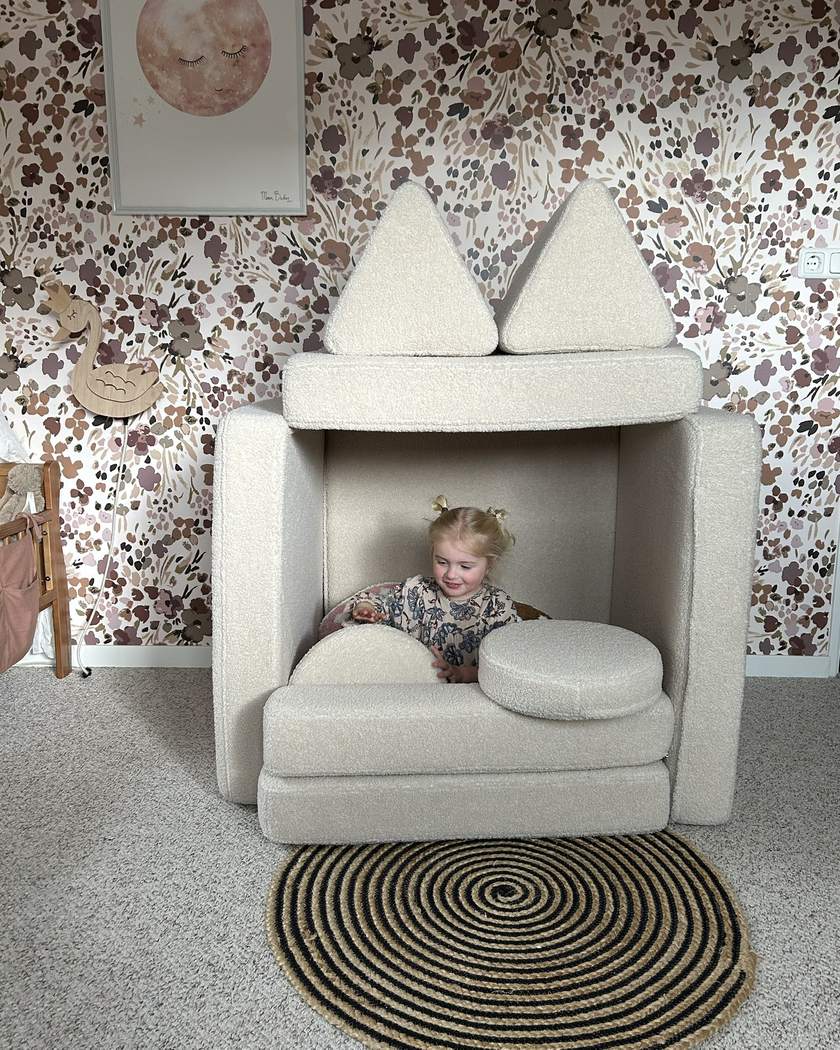 Dziecko siedzi w małym domku zbudowanym z Play Sofa Original Teddy