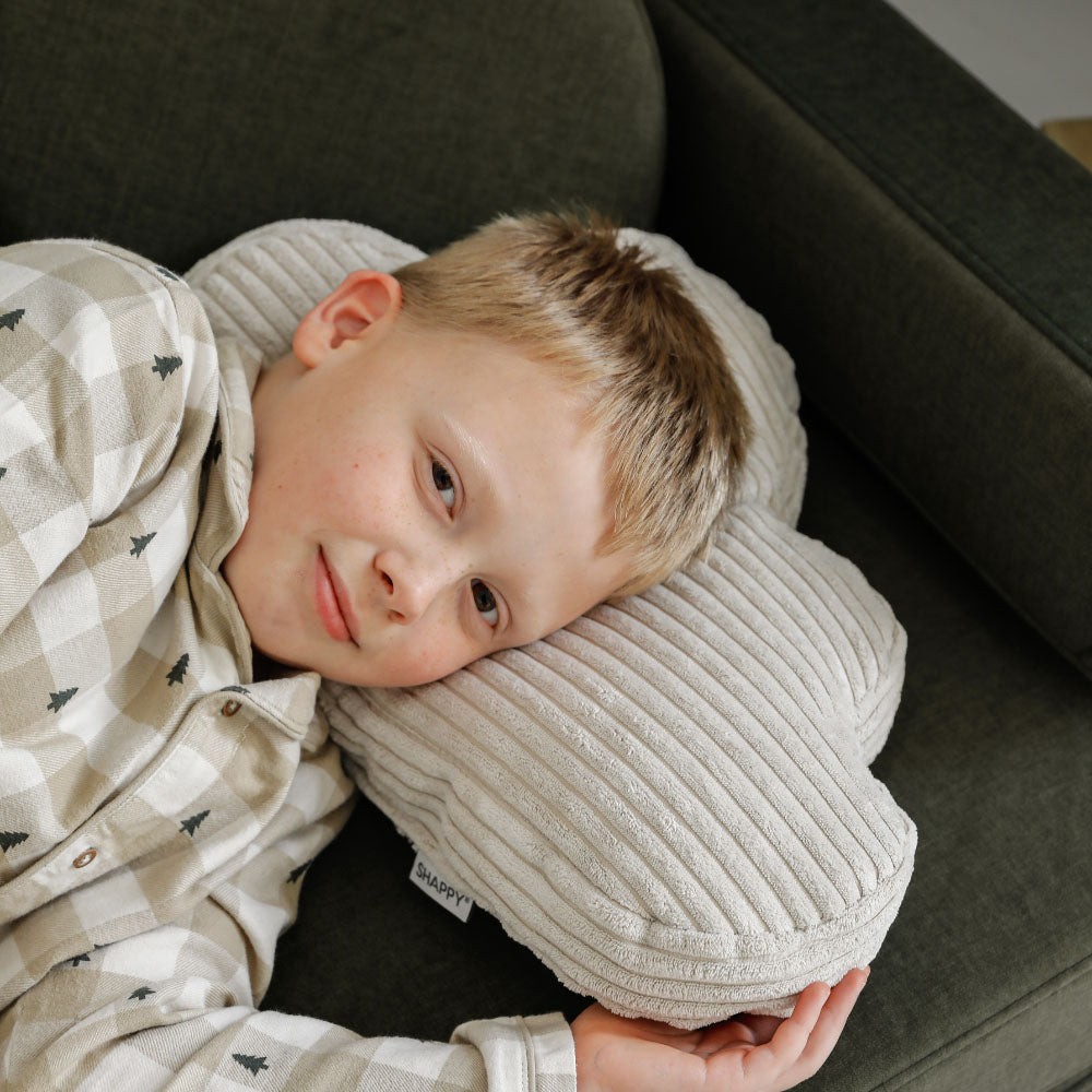 Chłopiec opiera głowę na poduszce Cloud Cushion
