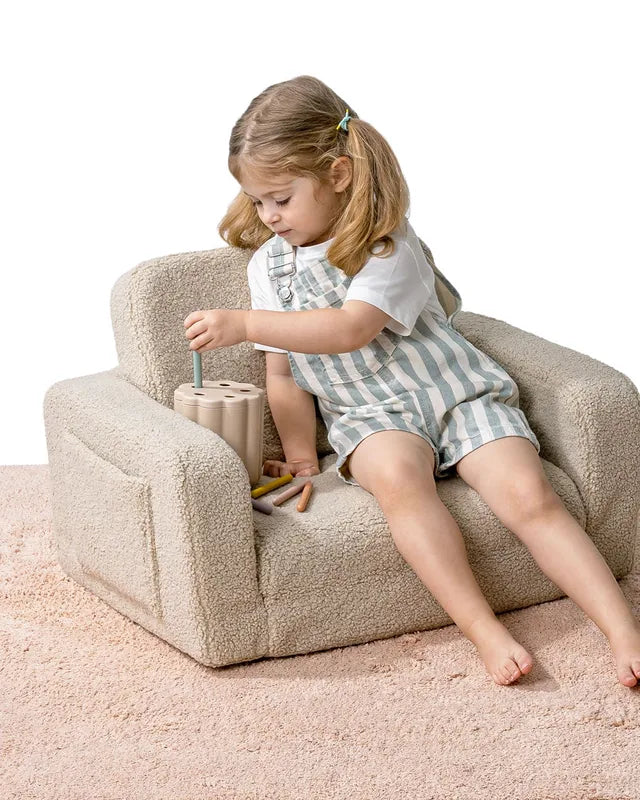 Dziecko siedzi w foteliku Lumi Chair Teddy