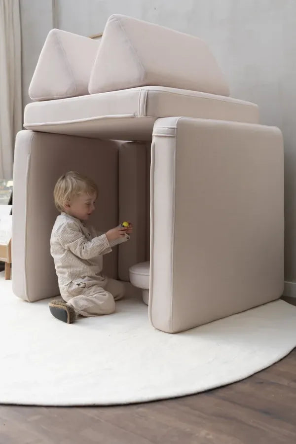 Maluch w małym domku zbudowanym z Play Sofa Original w kolorze Soft Beige