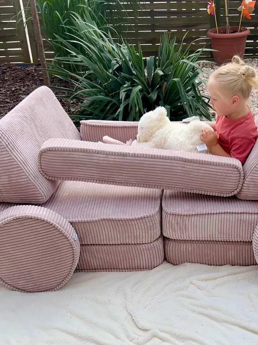 Dziewczynka bawi się w samochodzie zbudowanym z Play Sofa Original Corduroy w kolorze Candy