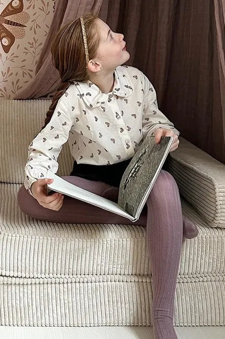 Dziewczynka czyta na Play Sofa Original Corduroy w kolorze Vanilla