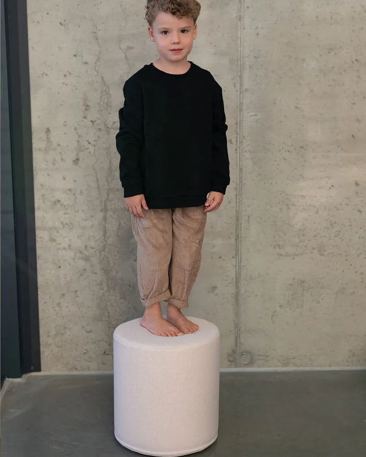 Chłopiec stoi na pufie Shappy Pouf Ultra Plush