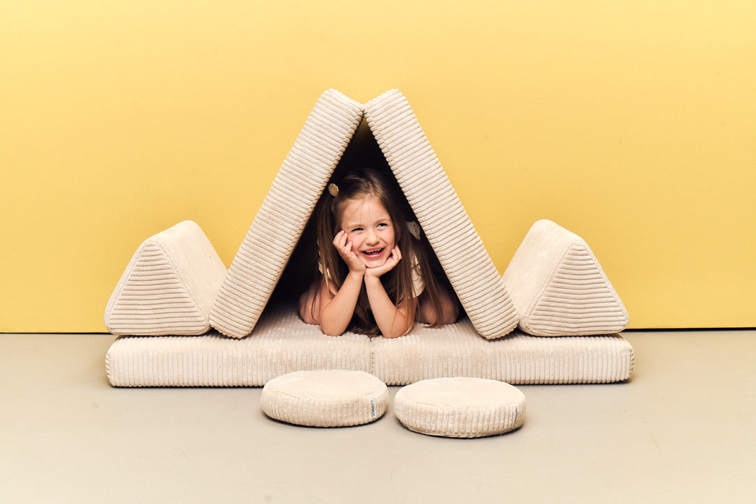 Dziecko bawi się w środku kryjówki zbudowanej z Play Sofa Pure Corduroy Mini w kolorze Vanilla