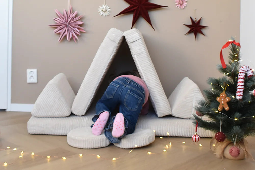 Dziecko bawi się w kryjówce zbudowanej z Play Sofa Pure Corduroy Mini w kolorze Vanilla