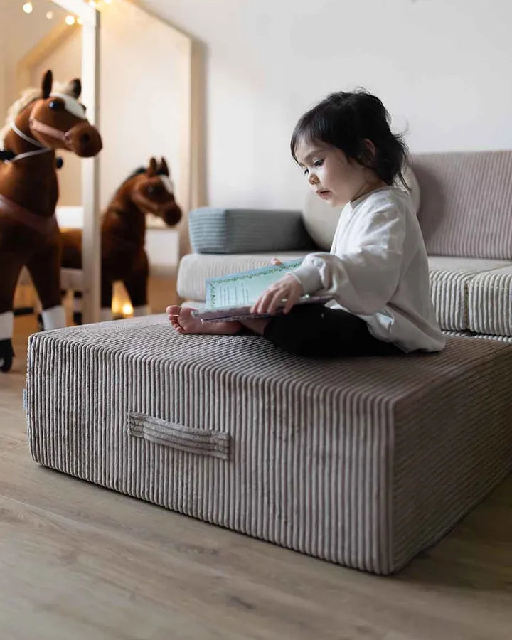 Dziewczynka siedzi z książką na Trampoline Pure Corduroy