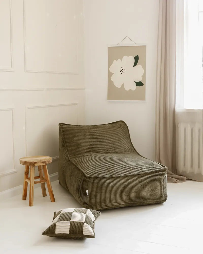 Kumo Lounger w pokoju, obok taboretu